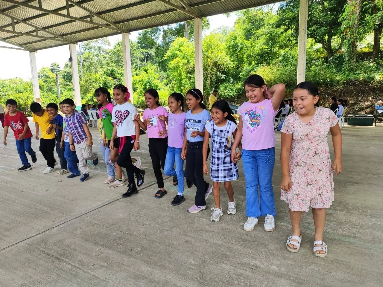 Niños participan en una actividad grupal bajo un techo abierto en la Huasteca